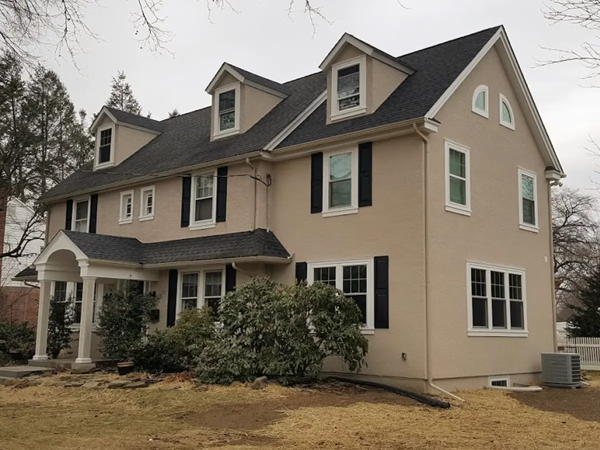 A large, beige mansion with white window frames