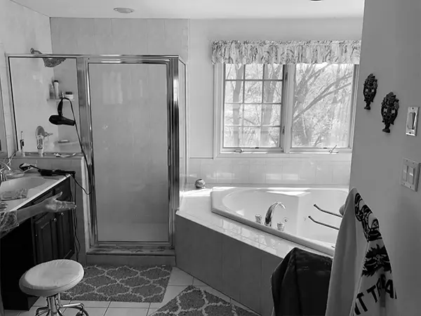 A dated bathroom with jacuzzi tub and old tile flooring