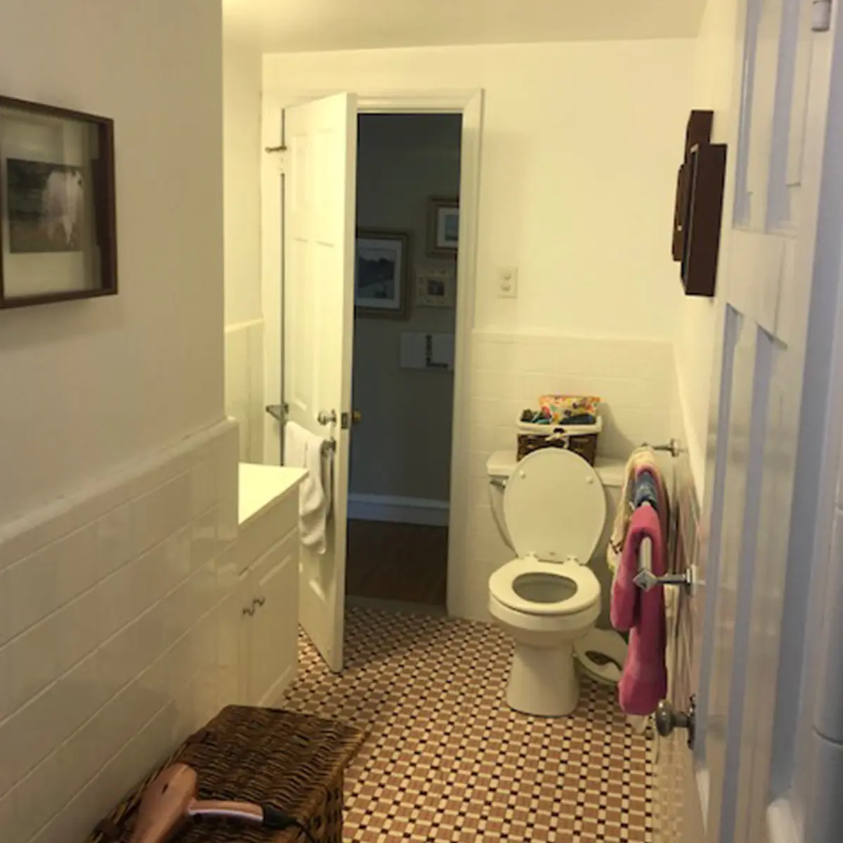 A dated bathroom with a toilet and colorful towels