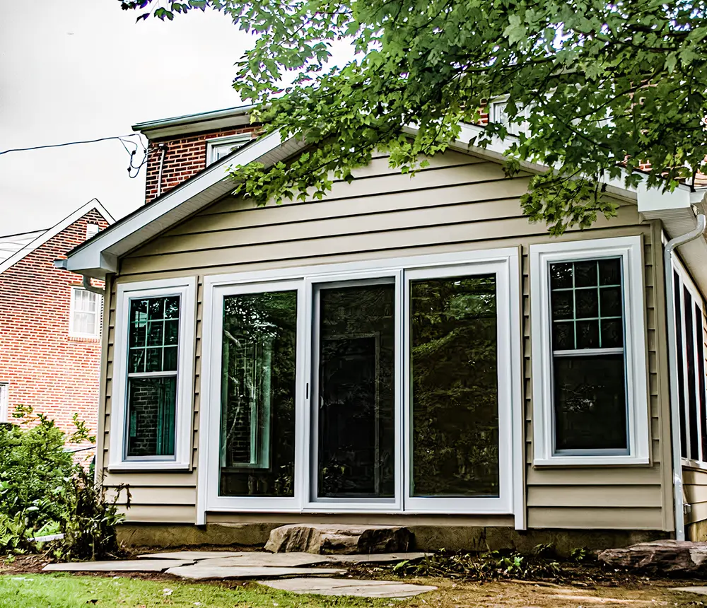 An mudroom with triple glass panels and beige siding