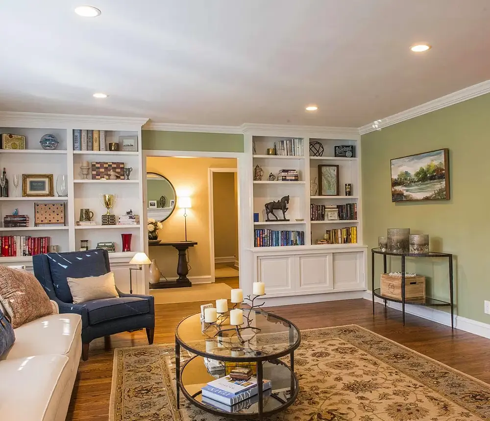 A living room with wood floors and open shelves