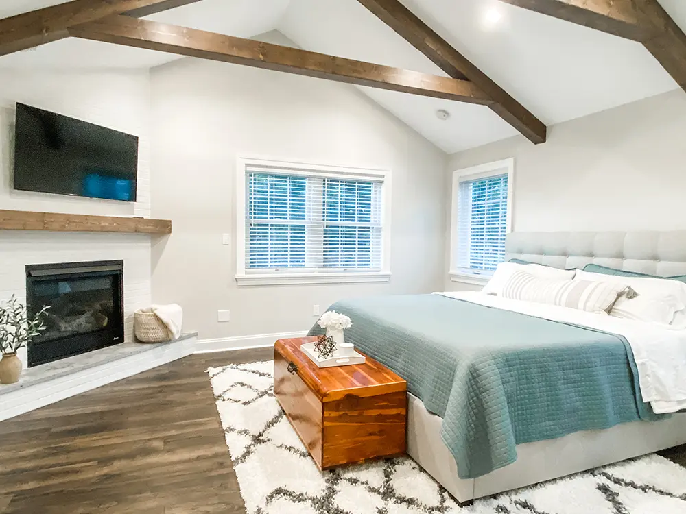 A bedroom with wood flooring and a bed with blue bedsheets