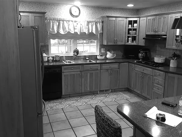A kitchen with old, wood cabinets before a remodel