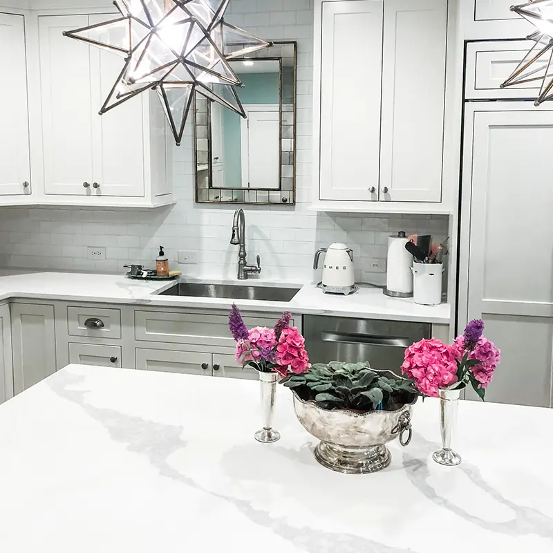 A beautiful new kitchen with a decorative plant and unique lights